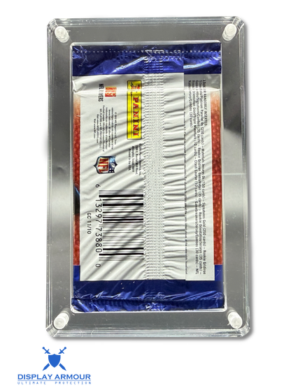 A sealed Panini trading card pack displayed inside a clear acrylic corner display case with white mounting dots, photographed on a white background. The pack is blue, white, and red, with a visible Panini logo and barcode.